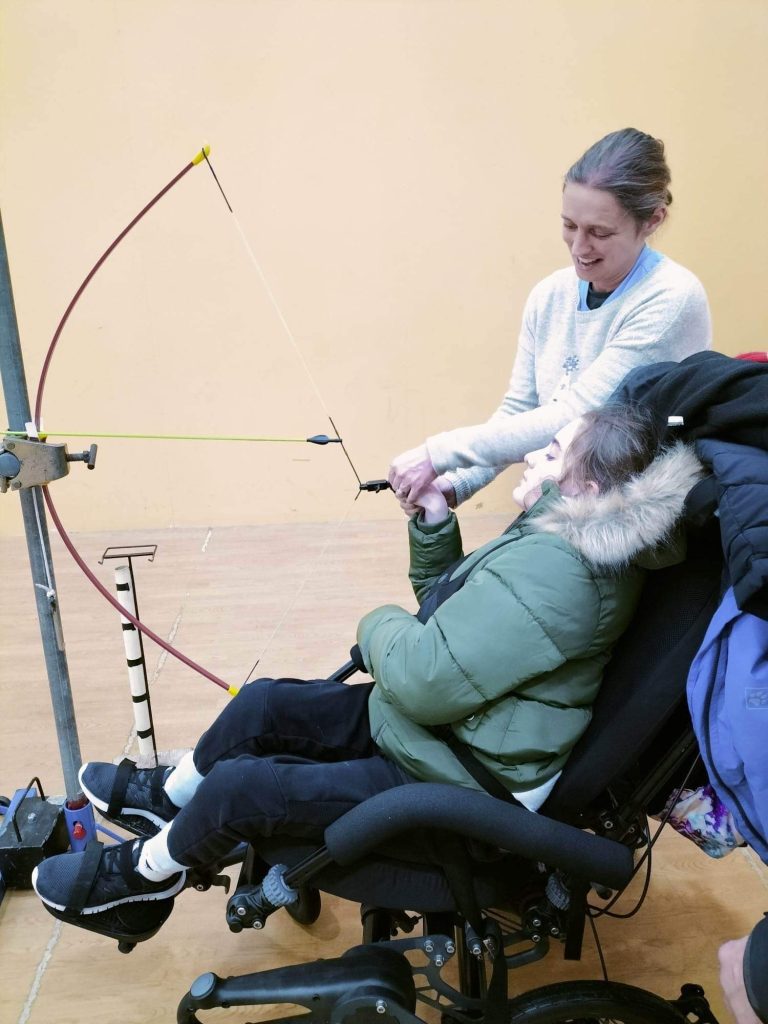 Ella, guest at Bendrigg Trust is taking part in archery which was enabled by the postural and support of the Chunc tilt in space wheelchair feature.